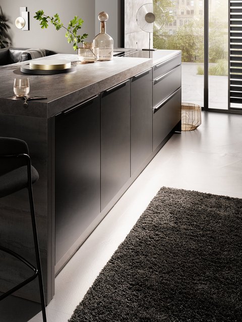 Luxe kookeiland met donker kleurige fronten, robuust werkblad en veel opbergruimte