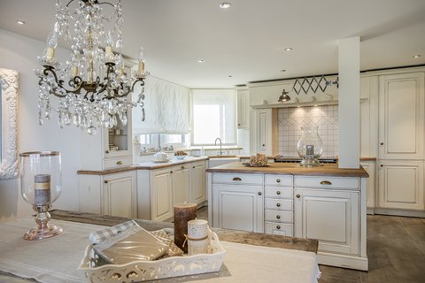 Luxuriöse Küche im Landhausstil von Oster Luxuriöse, weiße Küche im Landhausstil mit Kücheninsel von Oster